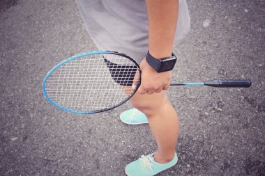 Genç kadın, shuttlecocks ve badminton raket.