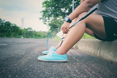 Genç kadın, shuttlecocks ve badminton raket.