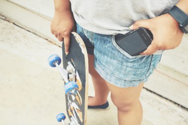 Kot pantolon cebinde kaykay ile akıllı telefon