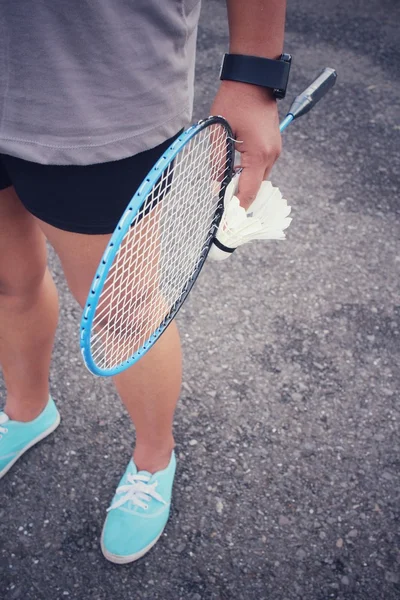 Ung kvinna med bollar och badmintonracketen. — Stockfoto