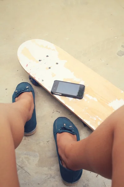 Селфи молодой девушки со смартфоном на скейтборде — стоковое фото