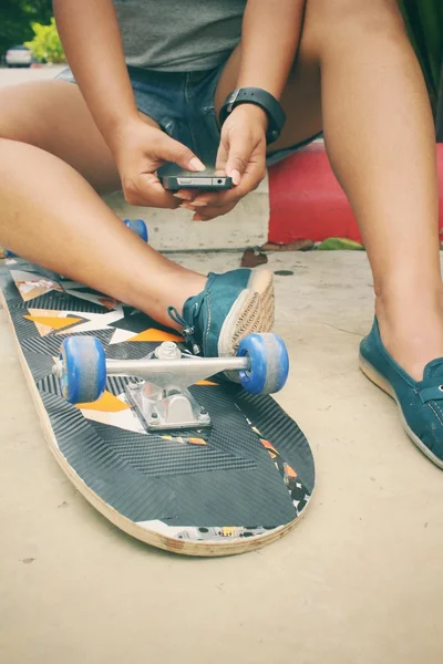 Селфи молодой девушки и смартфон со скейтбордом — стоковое фото
