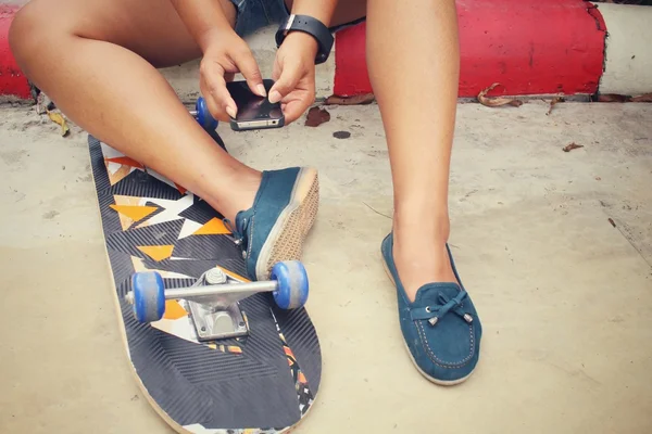 Selfie av ung flicka och smart telefon med skateboard — Stockfoto