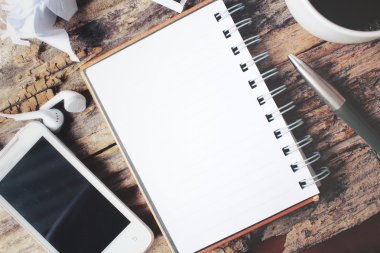 Boş not defteri ve Ofis Masası üzerinde sıcak kahve ile akıllı telefon