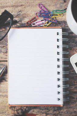 Boş not defteri ve Ofis Masası üzerinde sıcak kahve ile akıllı telefon