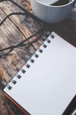 Boş not defteri ve sıcak kahve gözlüklerle Ofis masaları