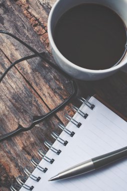 Boş not defteri ve sıcak kahve gözlüklerle Ofis masaları