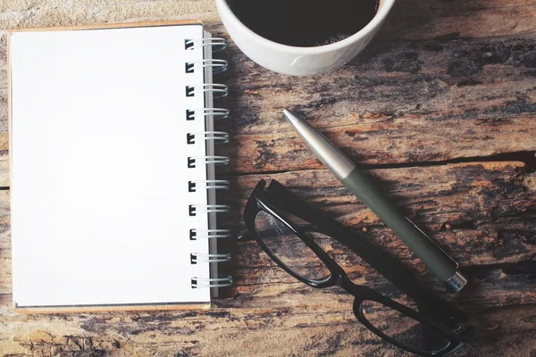 Lege Kladblok en slimme telefoon met warme koffie op office tafel — Stockfoto