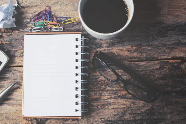 Bloco de notas em branco e caneta com café quente na mesa de escritório — Fotografia de Stock