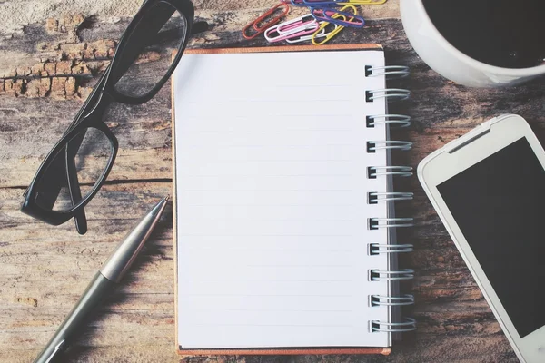 Boş not defteri ve Ofis Masası üzerinde sıcak kahve ile akıllı telefon — Stok fotoğraf
