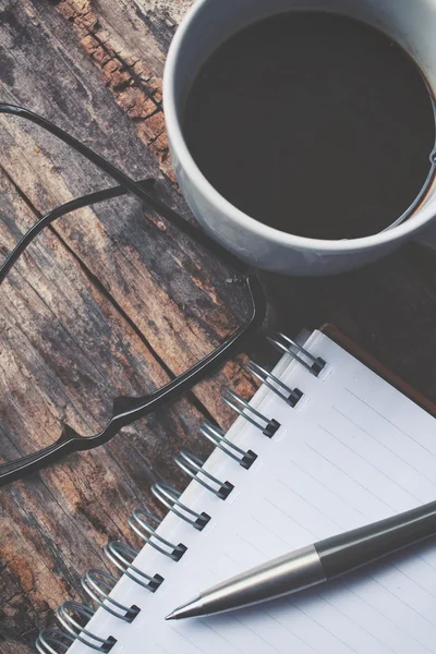 Lege Kladblok en warme koffie met een bril op kantoor tafel — Stockfoto