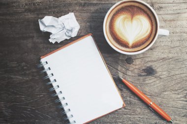 Boş not defteri ve kalem ile latte sanat Ofis Masası üzerinde kahve