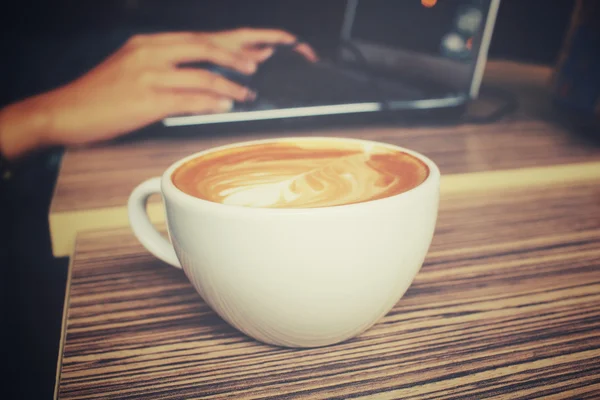 Vintage latte art kaffe med dator notebook — Stockfoto