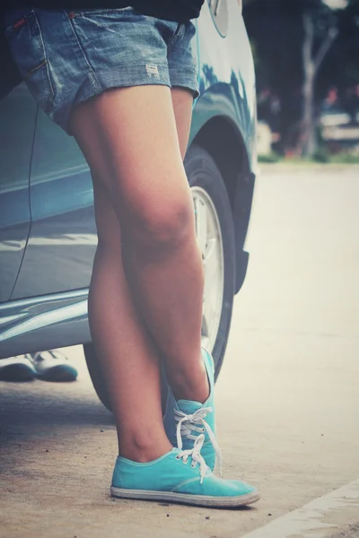 运动鞋和路上一辆车的女人 — 图库照片