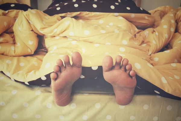 Feet in the bed — Stock Photo, Image