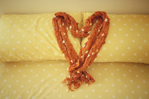 Herz aus Schal auf Bettkissen im Hotel — Stockfoto
