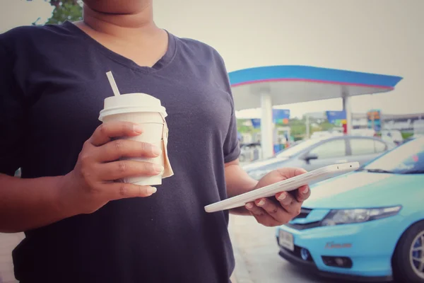 Mulher usando comprimido com xícara de papel de café — Fotografia de Stock