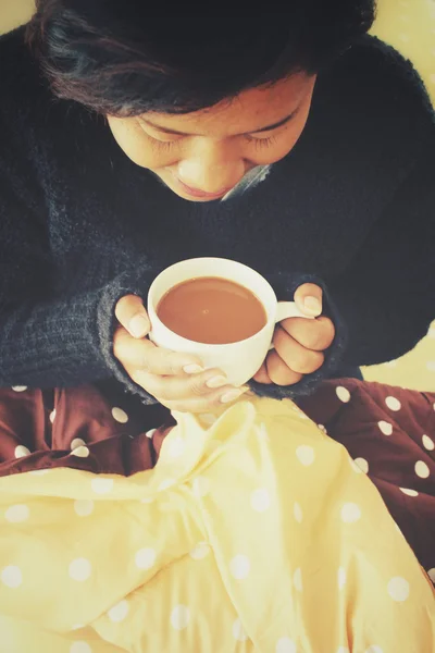ベッドの上のコーヒーを飲む女性 — ストック写真