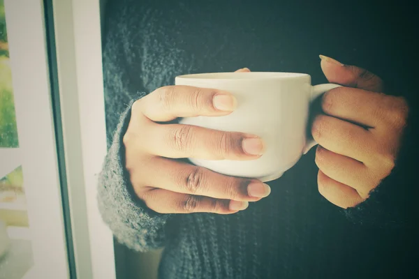 寝室の窓の近くのコーヒー カップを飲む女性 — ストック写真