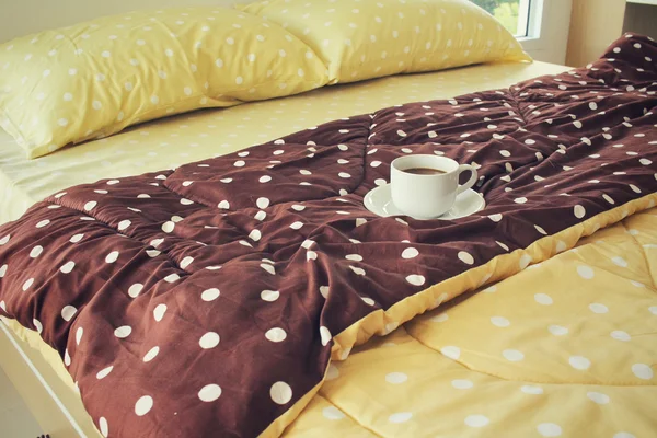 Kaffeetasse auf dem Bett — Stockfoto