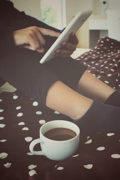 ベッドの上のコーヒー カップを搭載したタブレットします。 — ストック写真