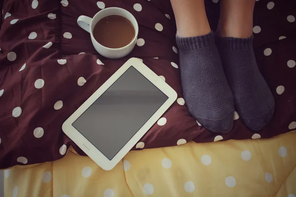 ベッドの上のコーヒー カップを搭載したタブレットします。 — ストック写真