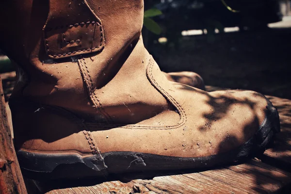 Oude laarzen met schaduw — Stockfoto