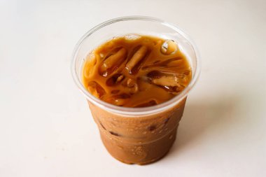 Buzlu kahve beyaz masada cam bardakta.