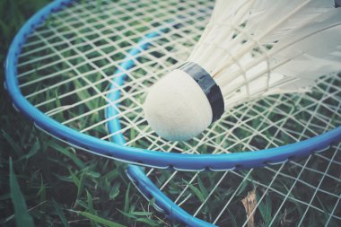 Yeşil çimenlerin üzerinde badminton raket ile shuttlecocks