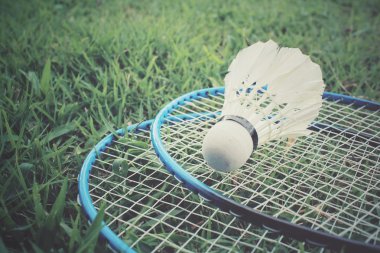 Yeşil çimenlerin üzerinde badminton raket ile shuttlecocks