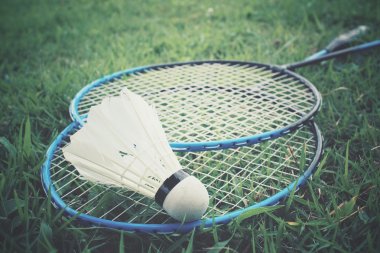 Yeşil çimenlerin üzerinde badminton raket ile shuttlecocks