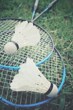 Yeşil çimenlerin üzerinde badminton raket ile shuttlecocks