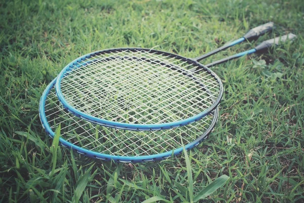 Badminton racket on green grass — Stock Photo, Image