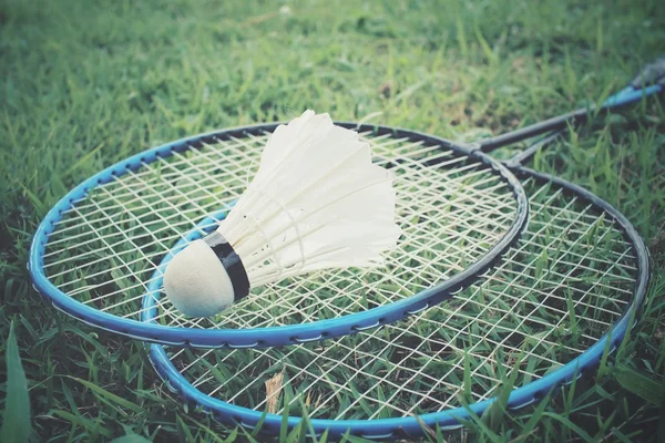 Opeřené s Badmintonové rakety na zelené trávě — Stock fotografie
