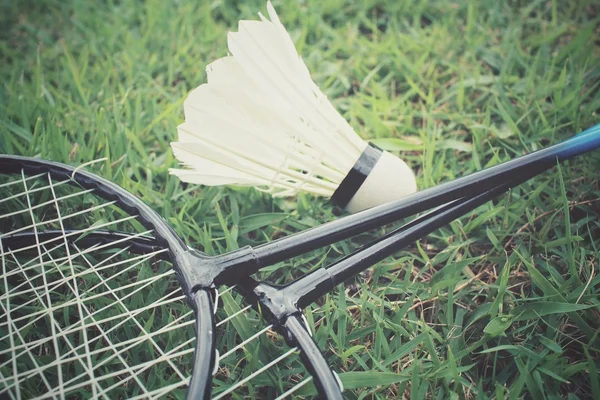 Shuttlecocks com raquete de badminton na grama verde — Fotografia de Stock