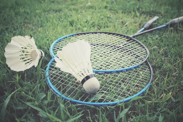 Shuttlecocks com raquete de badminton na grama verde — Fotografia de Stock