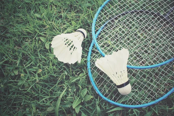 Shuttlecocks com raquete de badminton na grama verde — Fotografia de Stock