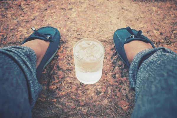 Селфи питьевой воды под рукой с обувью — стоковое фото