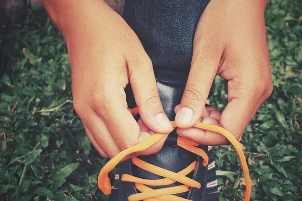 Руки завязывают шнурки — стоковое фото