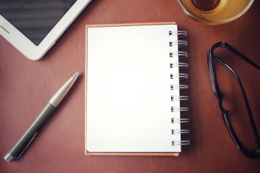 Boş not defteri ve Ofis Masası üzerinde sıcak çay ile akıllı telefon