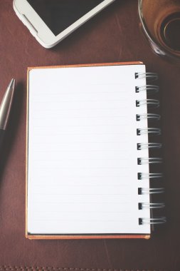Boş not defteri ve Ofis Masası üzerinde sıcak çay ile akıllı telefon