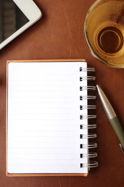 Boş not defteri ve Ofis Masası üzerinde sıcak çay ile akıllı telefon