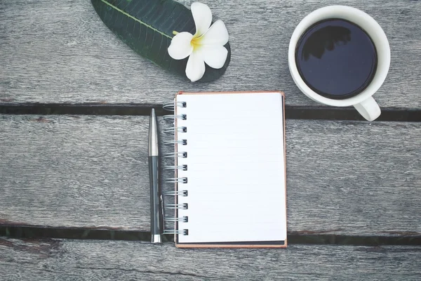 Blocco note e penna in bianco con tazza di caffè sul tavolo dell'ufficio — Foto Stock