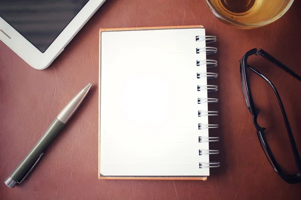 Lege Kladblok en slimme telefoon met hete thee op office tafel — Stockfoto