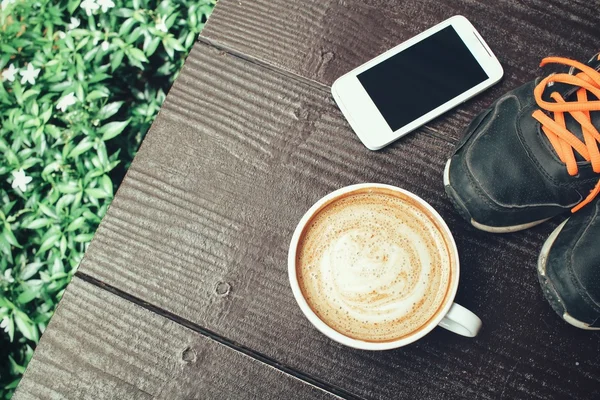 Latte kávé és smartphone-val cipők — Stock Fotó