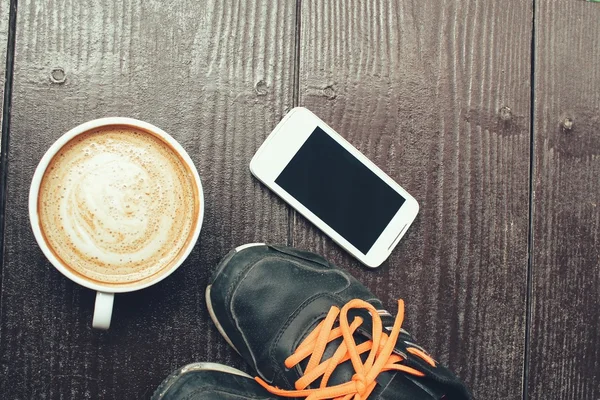 Латте кава і смартфон з кросівками — стокове фото