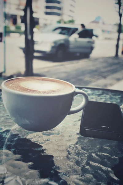 Vintage Latte Art Kaffee mit Smartphone — Stockfoto