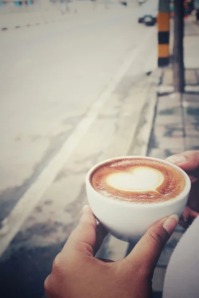 Frau trinkt Latte-Art-Kaffee — Stockfoto