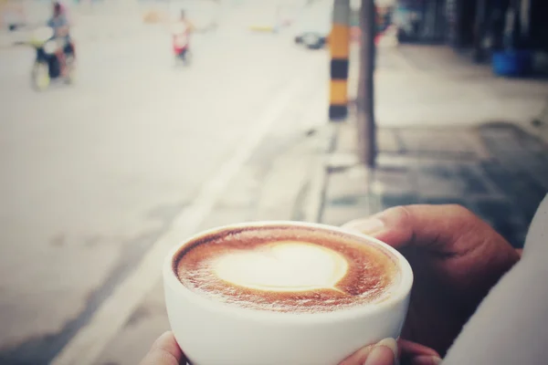 Frau trinkt Latte-Art-Kaffee — Stockfoto