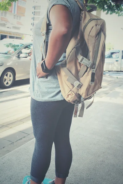 Mulher turista com uma mochila de pé na estrada — Fotografia de Stock